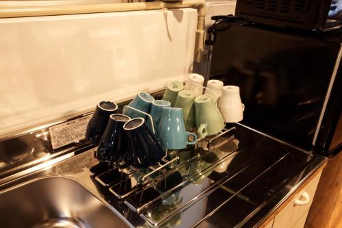 a group of cups sitting on top of a stove at Guest House Re-worth Yabacho1 1F in Nagoya