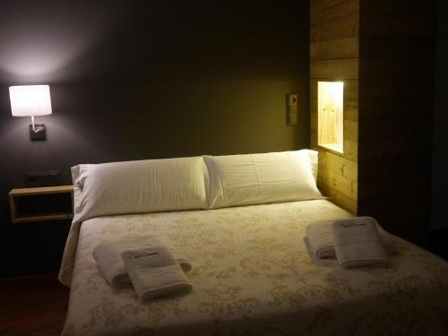 
a bed room with a white bedspread and a lamp at Hotel Apartamentos Domenc in Aren
