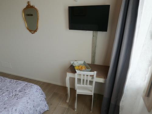 - une chambre avec une table, une chaise et une télévision dans l'établissement El Sesterzio, à Oderzo