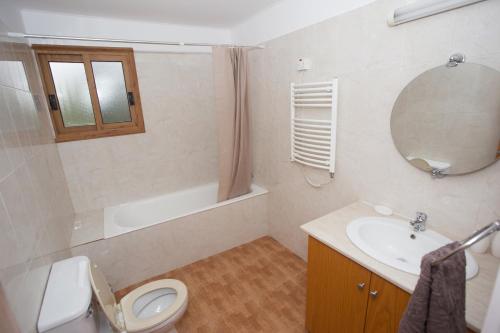a bathroom with a toilet and a sink and a mirror at Serene Serenity in Paphos