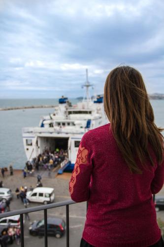 a woman standing on a balcony looking at a boat at Vento di mare in Procida