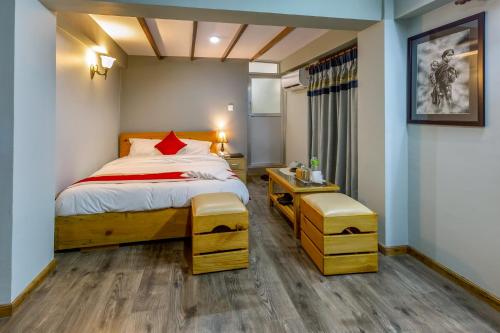 a bedroom with a large bed with a red pillow at Inn Sangrahalaya in Bhaktapur