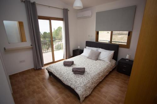 a bedroom with a bed with two towels on it at Serene Serenity in Paphos