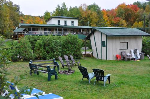 a group of chairs in a yard with a building at Le Boisé du Lac in Mont-Tremblant