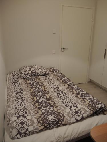 a bed with a black and white blanket on it at Pearl in Raahe