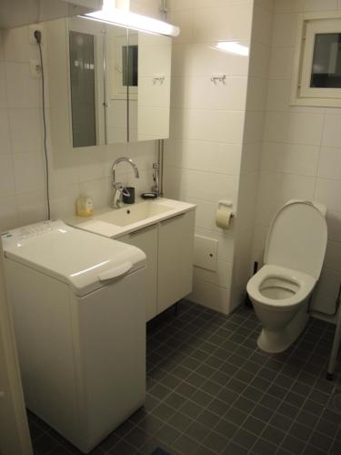 a white bathroom with a toilet and a sink at Pearl in Raahe