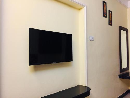 a flat screen tv hanging on a wall at Hotel Sun Rock in Kanyakumari