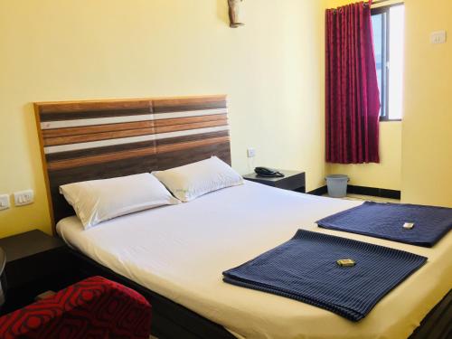a bedroom with a bed with two towels on it at Hotel Sun Rock in Kanyakumari