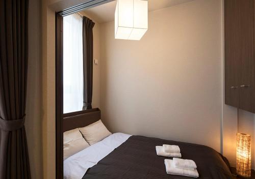 a bedroom with a bed with two towels on it at PINN-N4E2Ⅰ in Sapporo