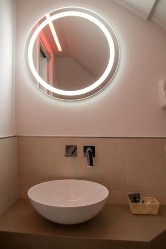 a bathroom sink with a round mirror on the wall at Vento di mare in Procida