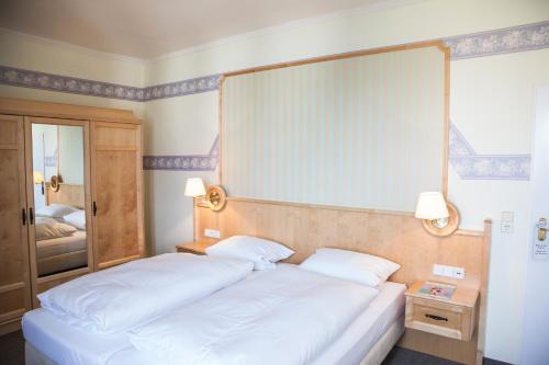 a bedroom with two white beds and a mirror at Hotel Altes Kurhaus in Baabe