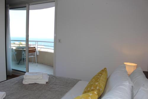 a bedroom with a bed and a view of the ocean at Sunny one bed, sea view, larvotto beach, Monaco in Beausoleil