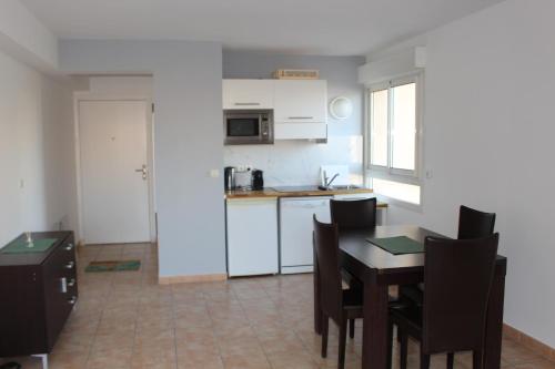 une cuisine et une salle à manger avec une table et des chaises dans l'établissement Sunny one bed, sea view, larvotto beach, Monaco, à Beausoleil