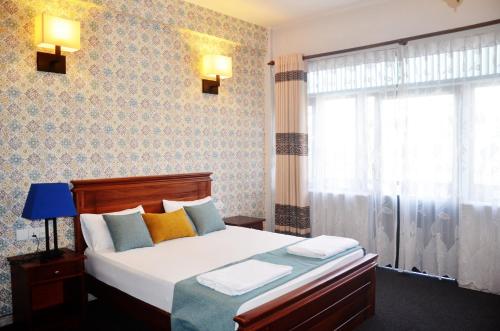 a bedroom with a bed and a window at Blinkbonnie Inn in Kandy