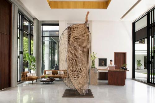 a large wicker sculpture in the middle of a lobby at Treeline Urban Resort in Siem Reap