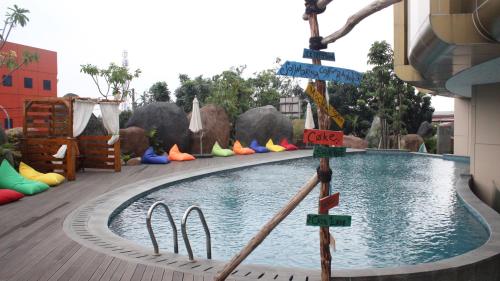 a swimming pool with street signs in front of a building at Grand Soll Marina Hotel in Tangerang