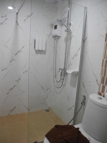 La salle de bains est pourvue d'une douche, de toilettes et d'une porte en verre. dans l'établissement Bann Tawan Hostel Chiang Rai, à Chiang Rai