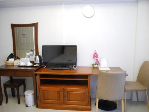 a desk with a laptop computer and a chair at Bann Tawan Hostel & Spa in Chiang Rai
