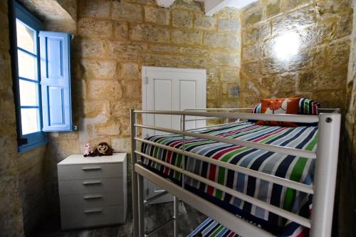 ein Schlafzimmer mit einem Etagenbett in einer Steinmauer in der Unterkunft Historic Townhouse in Birgu Center in Vittoriosa