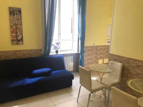 un soggiorno con divano blu e tavolo di B&B Quattro Palazzi Napoli Centro a Napoli