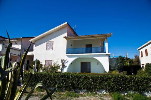 a white house with a balcony on top of it at villa francesca e cristina in Ferruzzano