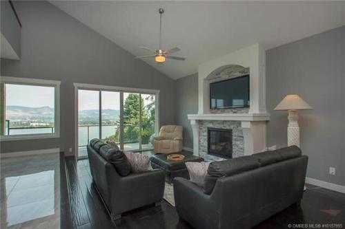 a living room with two couches and a fireplace at Lake and Bridge View Vacation Home in West Kelowna