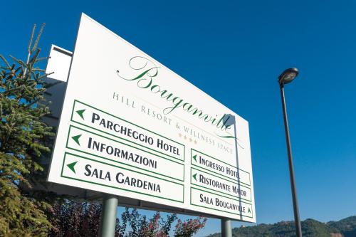 a white sign with arrows on a pole at Bouganville Hill Resort & Wellness Space in Picerno