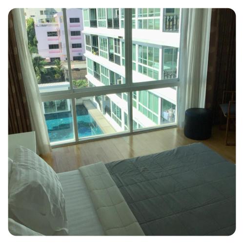 a bedroom with a bed and a large window at Apartment in Ranghill Residence Phuket by month in Phuket