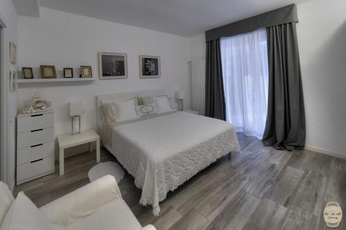 a white bedroom with a bed and a window at Ca' Du Ale in Sestri Levante