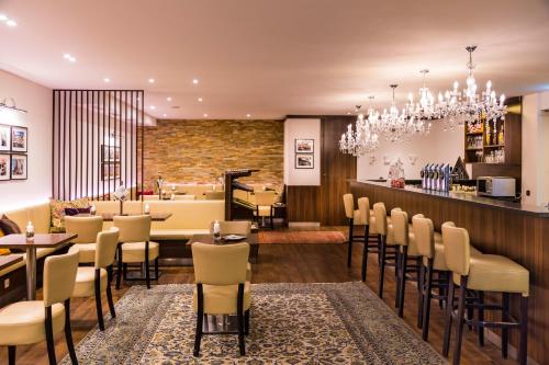 a restaurant with a bar with chairs and a counter at Apartments am Kalvarienberg in Graz