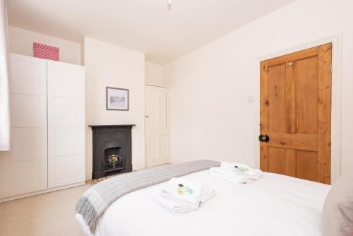 a white bedroom with a bed and a fireplace at Charming Base for 6 Near Bishy Rd - Pass the Keys in York