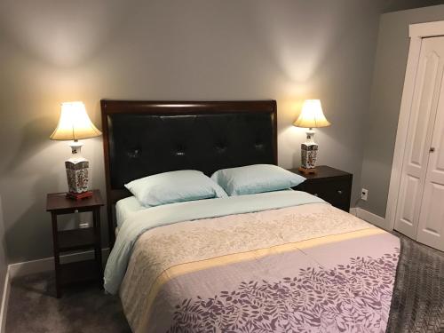 a bedroom with a large bed with two lamps at Lake and Bridge View Vacation Home in West Kelowna