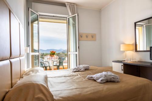 a bedroom with a bed and a balcony with a view at Hotel Columbia Terme in Abano Terme