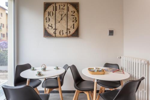 two tables and chairs with a clock on the wall at Le stanze di Carla! Con cucina e bagno privato in Florence