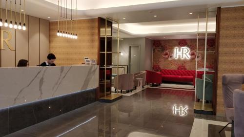 a lobby with a bar and a red couch at Hotel Roma in Trieste