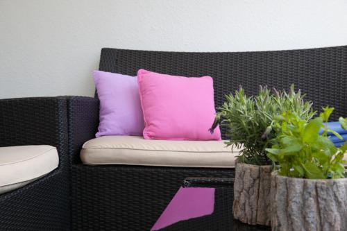 a couch with pink and purple pillows and potted plants at Hotel Altes Kurhaus in Baabe