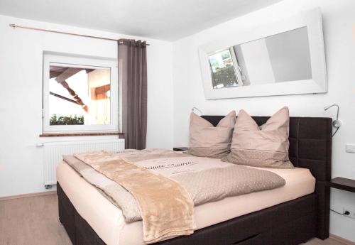 a bedroom with a black bed with pillows and a window at Ferienhaus Butterfly in Garmisch-Partenkirchen