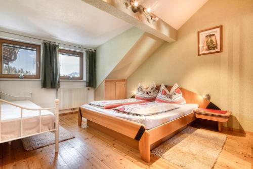 een slaapkamer met een bed en 2 ramen bij Chalet Fischer by A-Appartments in Bürserberg