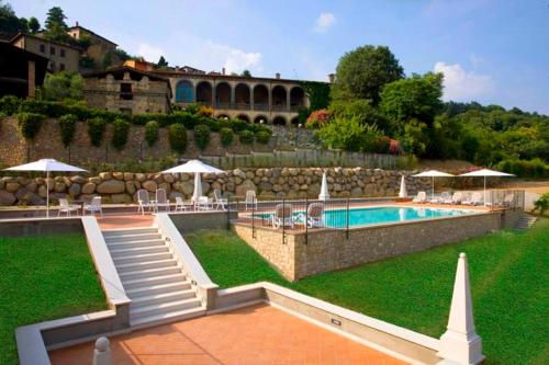 a pool with chairs and umbrellas next to a building at Corte Lantieri in Capriolo