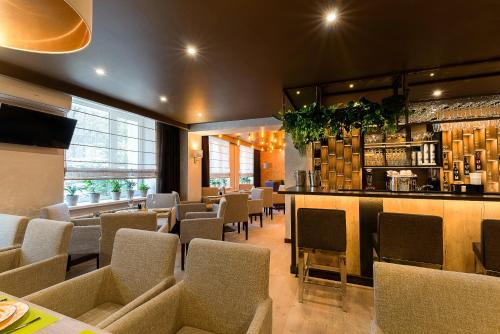 a restaurant with a bar with chairs and a counter at Sedanka Park Hotel in Vladivostok