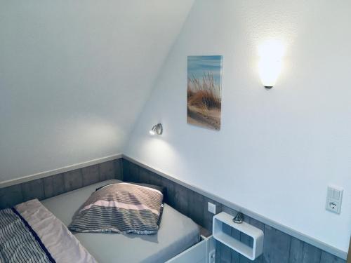 ein kleines Zimmer mit einem Bett und einem Bild an der Wand in der Unterkunft Ferienhaus Holst Sylt in Wenningstedt-Braderup