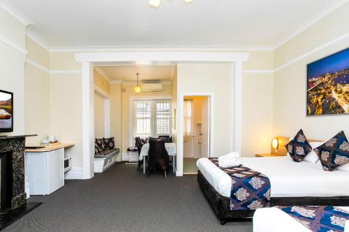Habitación de hotel con 2 camas y escritorio en The North Shore Hotel en Sídney