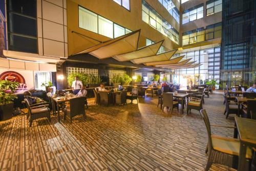 a restaurant with people sitting at tables in a building at BMK House Apartments in Kampala