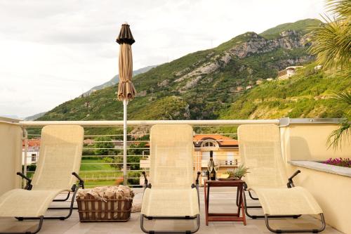 a group of chairs and an umbrella on a balcony at Eco Hotel Bonapace in Nago-Torbole
