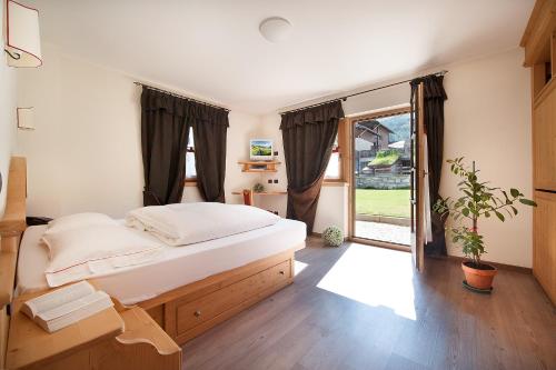 a bedroom with a bed and a large window at Hotel Meeting in Livigno
