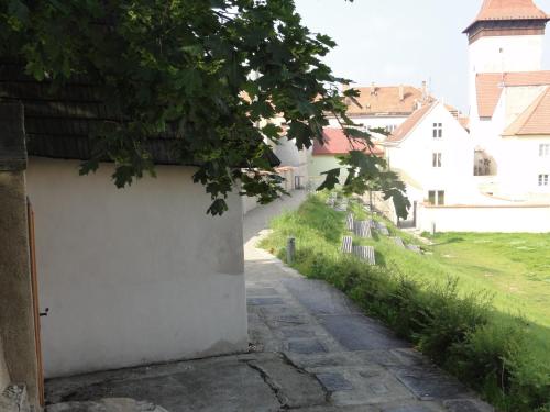 an alley in a village with a white wall at Penzion U Hradeb in Znojmo