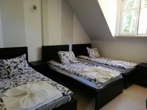 three beds sitting in a room with a window at Noclegi Lidzbark -Stacja Paliw k Lidzbarka in Lidzbark