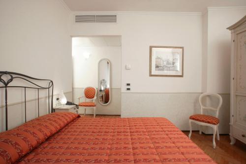 a bedroom with a bed and two chairs and a mirror at Ca' San Rocco in Venice