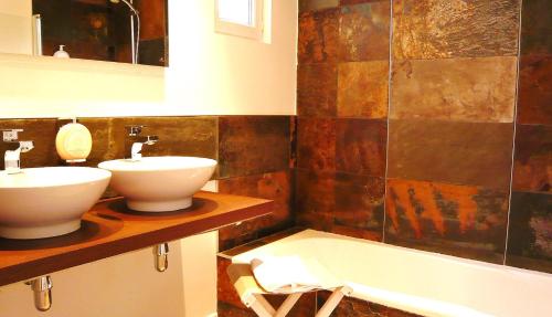 a bathroom with two sinks and a bath tub at San-Val' Eau in Froideterre