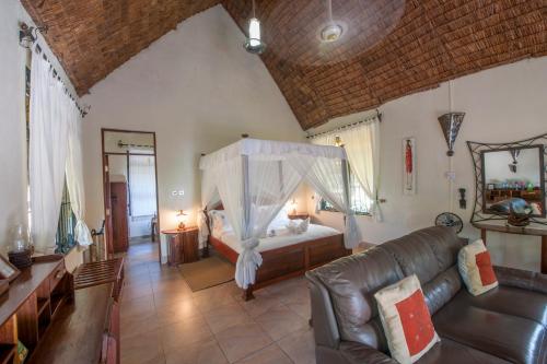 a bedroom with a bed and a couch in a room at Serenity on the Lake in Kalemera